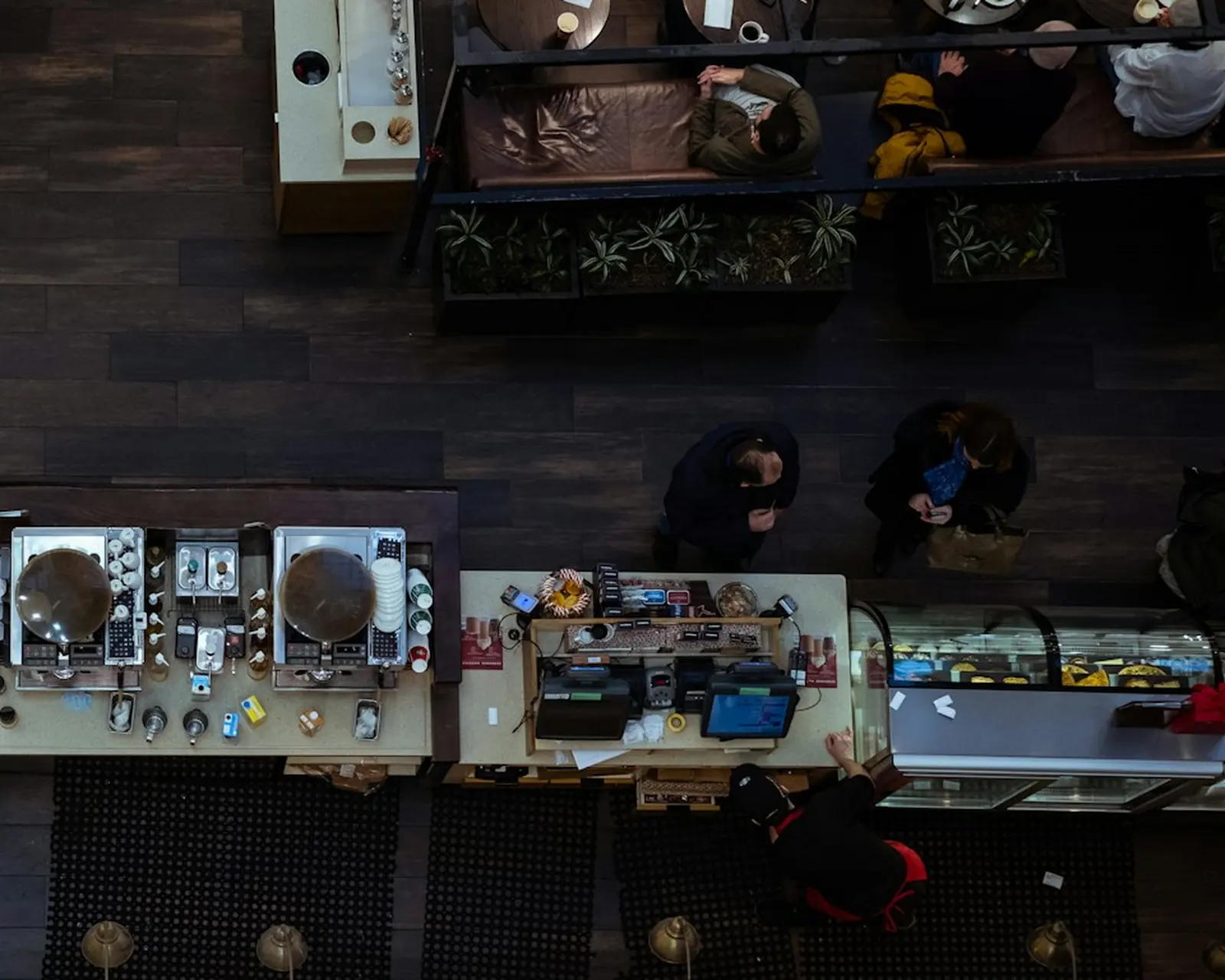 A café counter seen from above, customers waiting in line