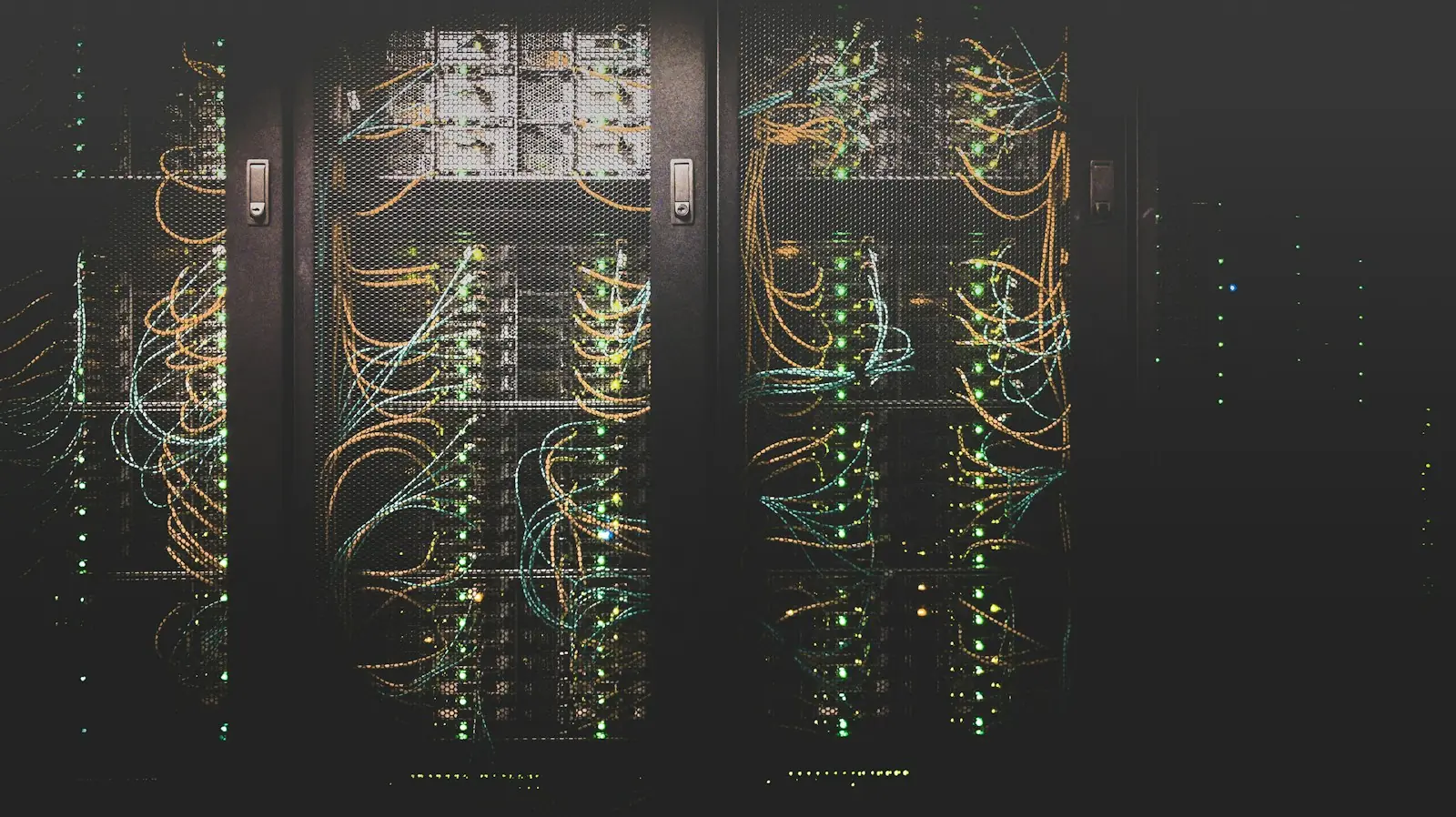 Server cabinets in a dark data centre, cabling and status lights