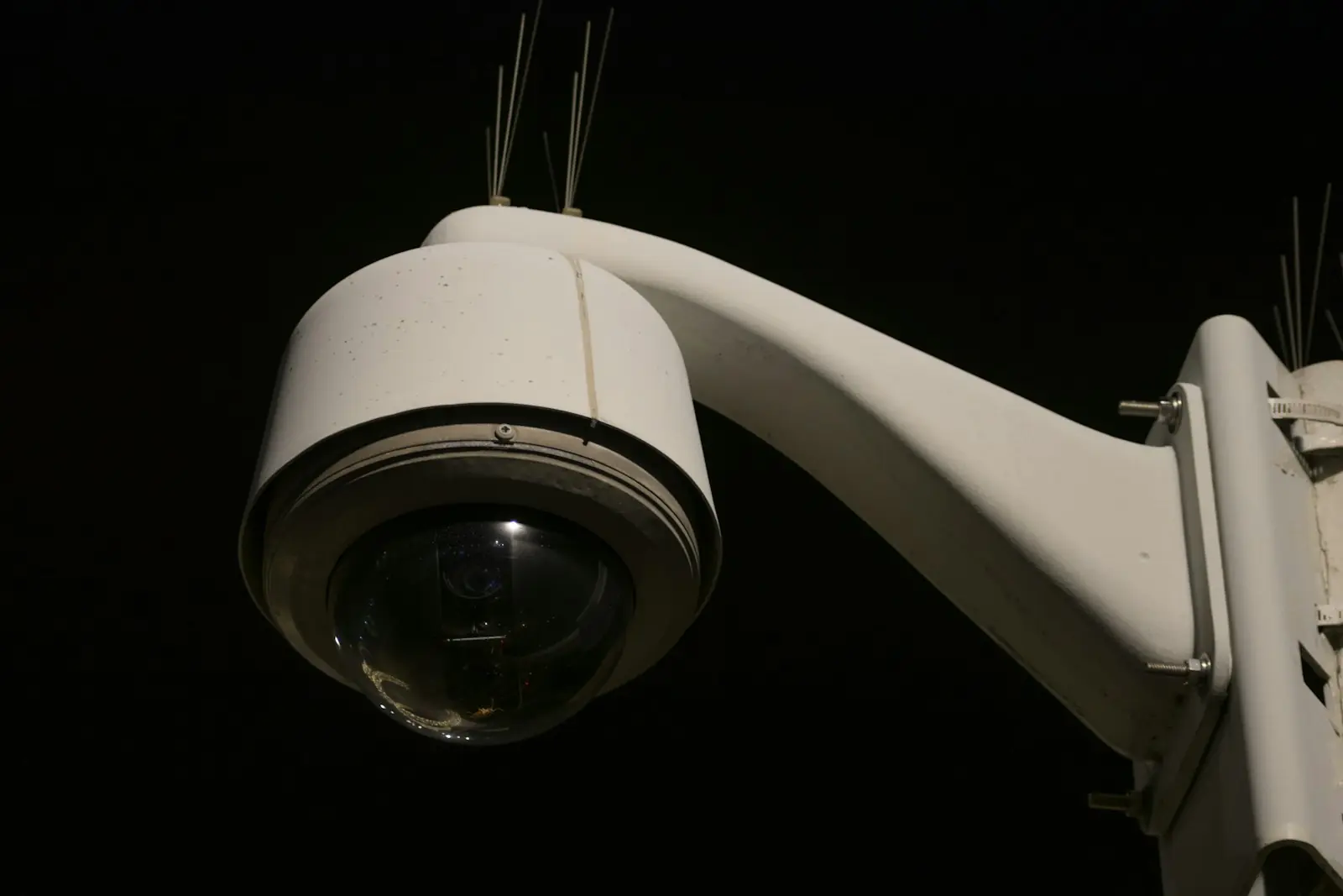 A dome security camera against the night sky